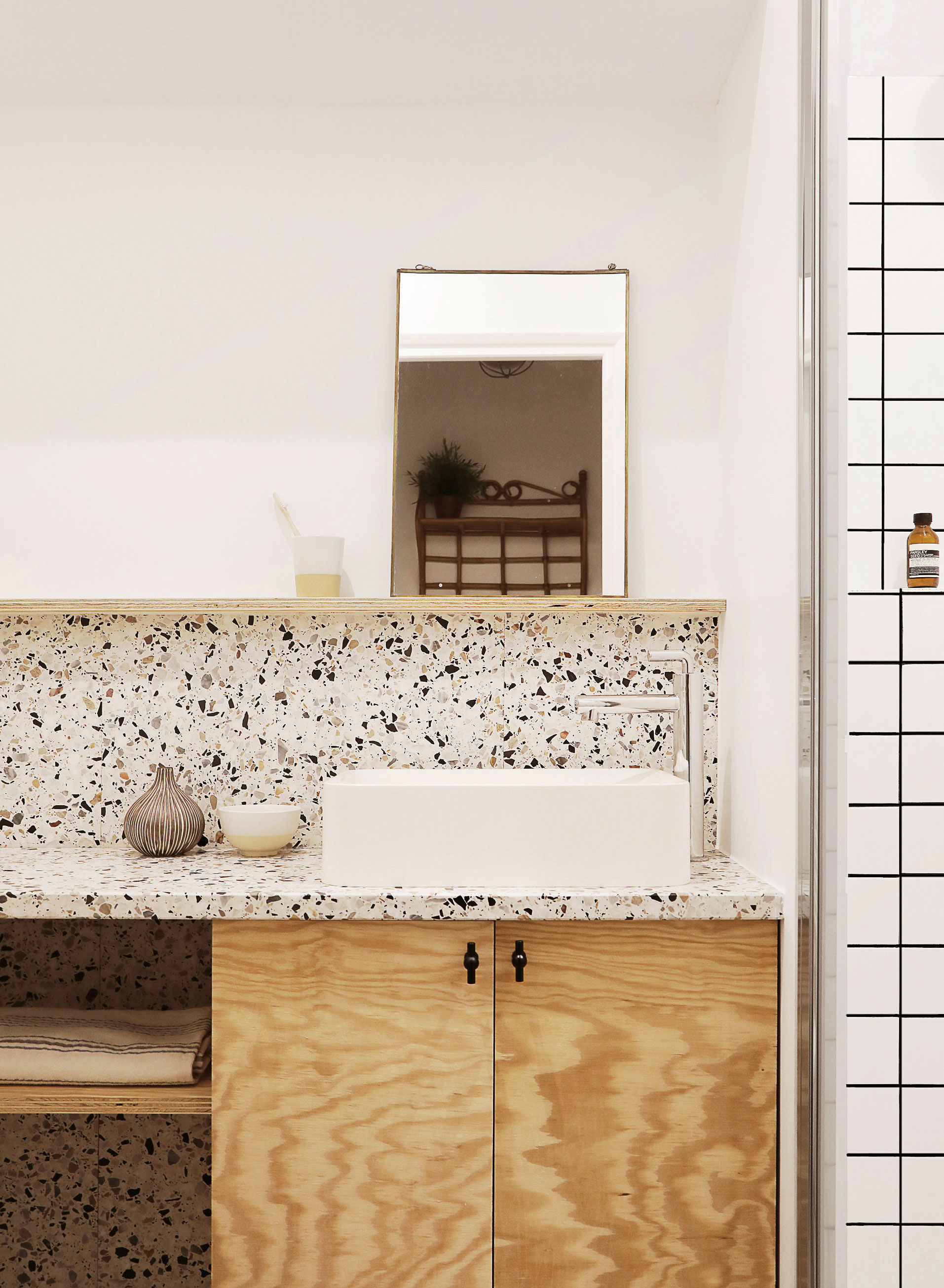 Une salle de bain en terrazzo et contreplaqué